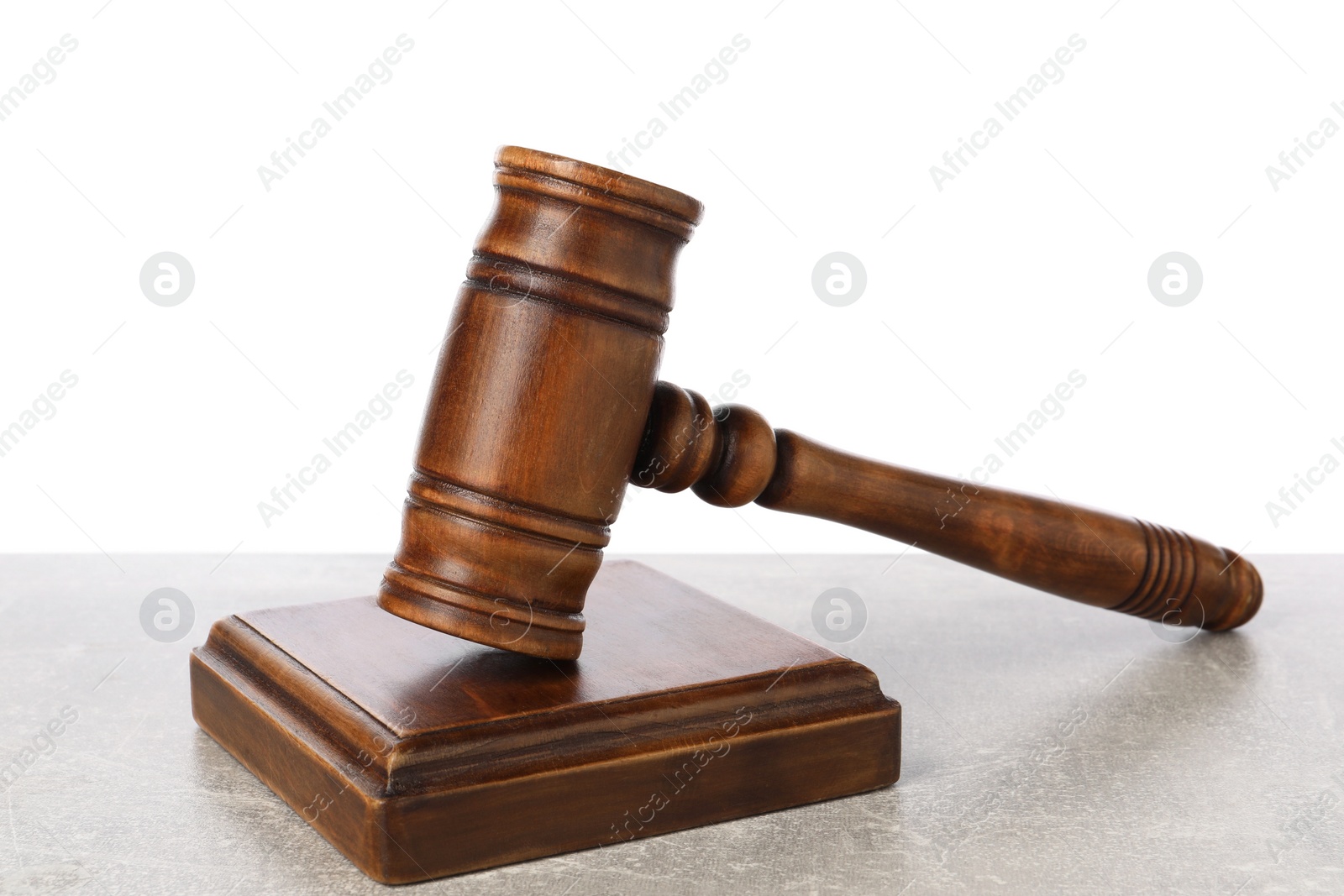 Photo of Wooden gavel on light table against white background