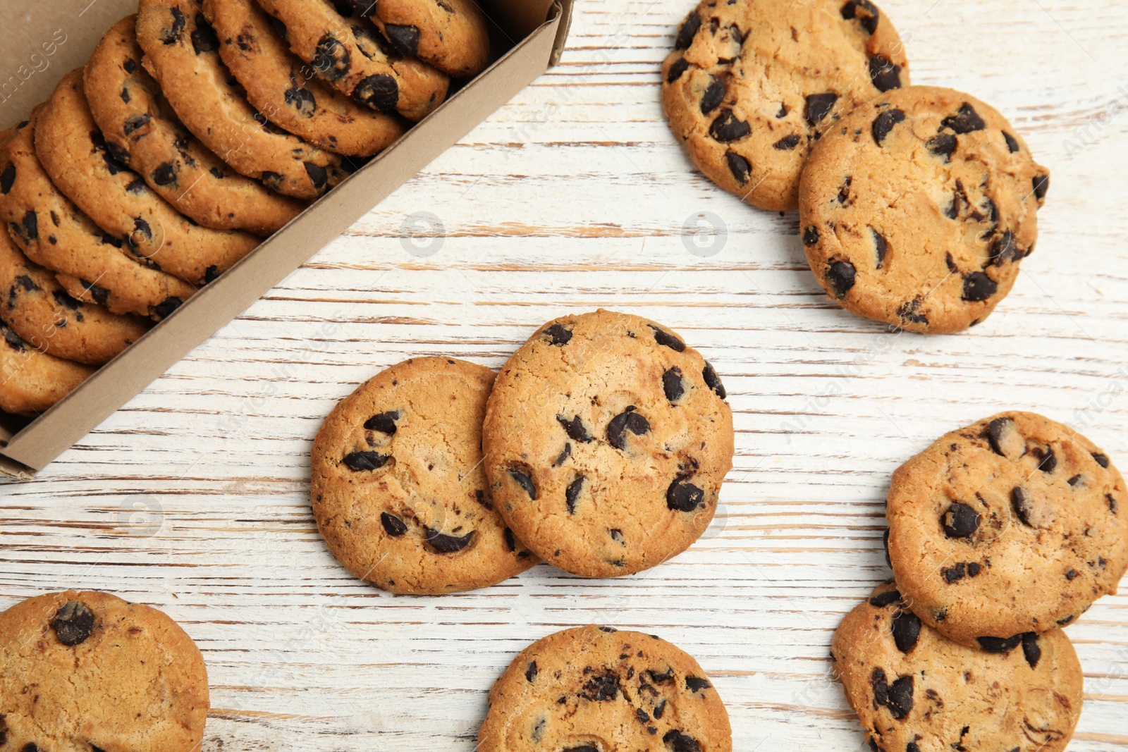 Photo of Delicious chocolate chip cookies on wooden table, flat lay