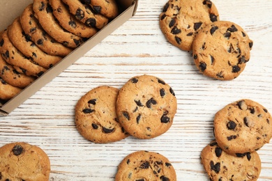 Delicious chocolate chip cookies on wooden table, flat lay