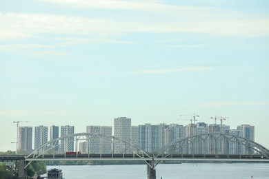 Photo of Beautiful view of cityscape with modern buildings and bridge over river