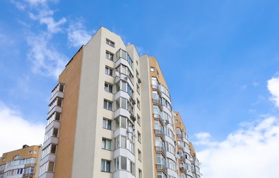 Photo of Exterior of multi-storey apartment building against blue sky, low angle view