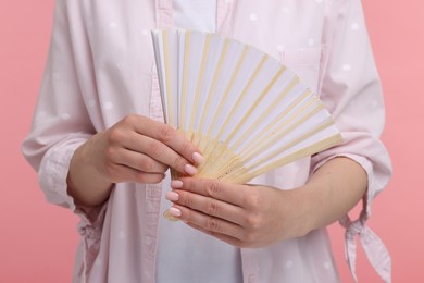 Photo of Woman with hand fan on pink background, closeup