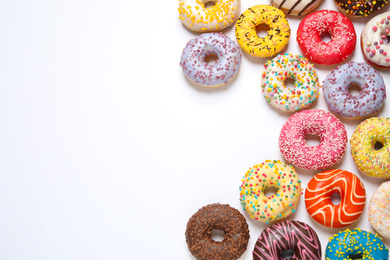 Delicious glazed donuts on white background, flat lay. Space for text