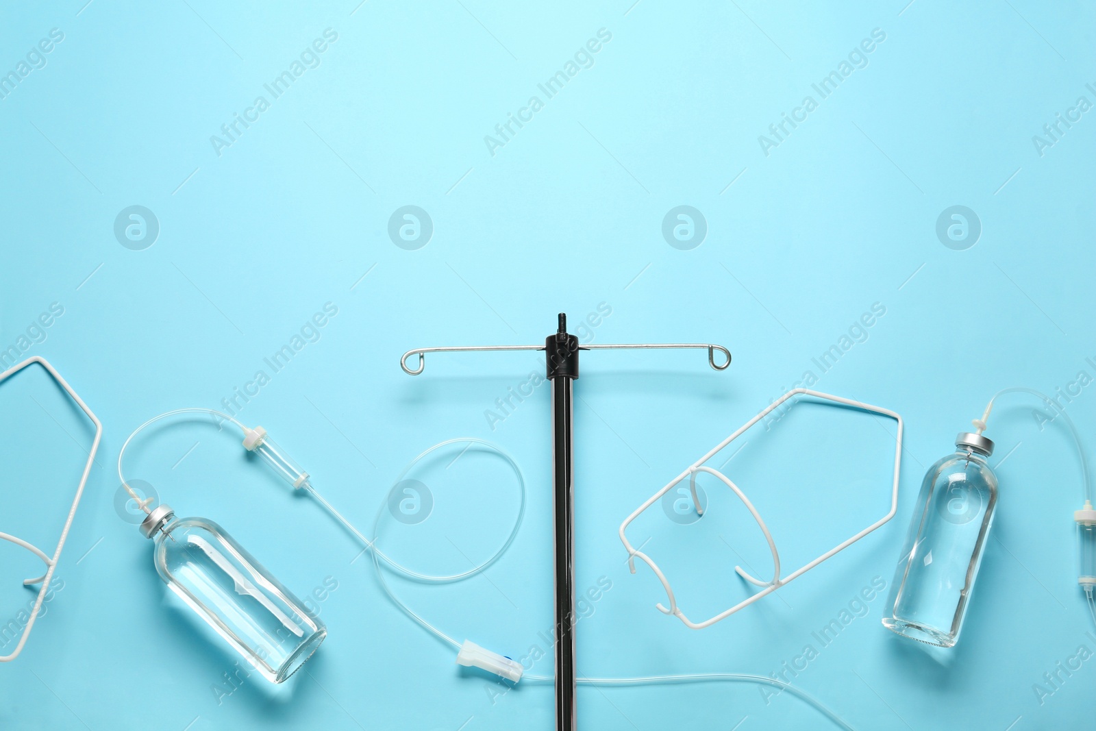 Photo of IV infusion set on light blue background, flat lay. Space for text