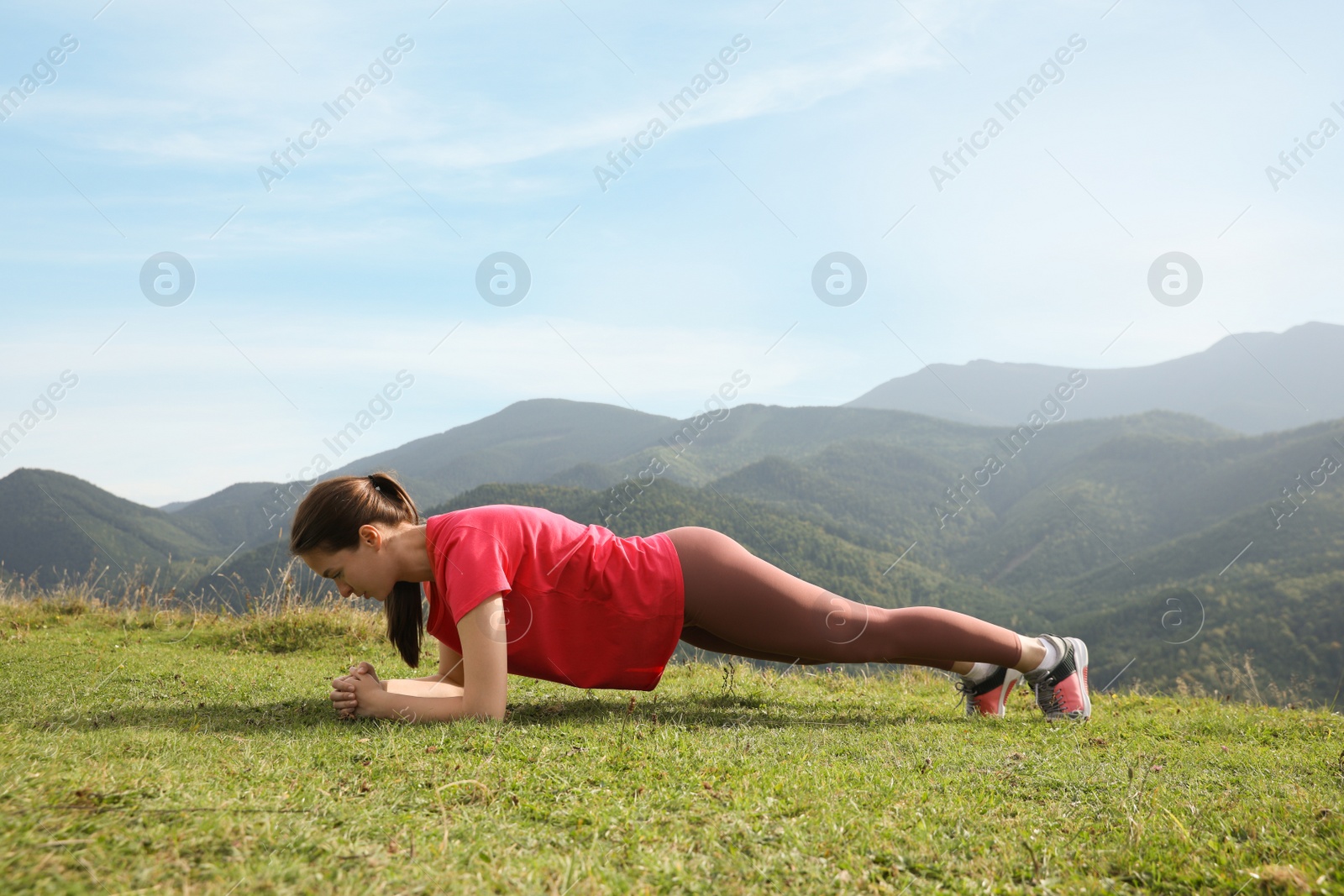 Photo of Young woman doing morning exercise in mountains