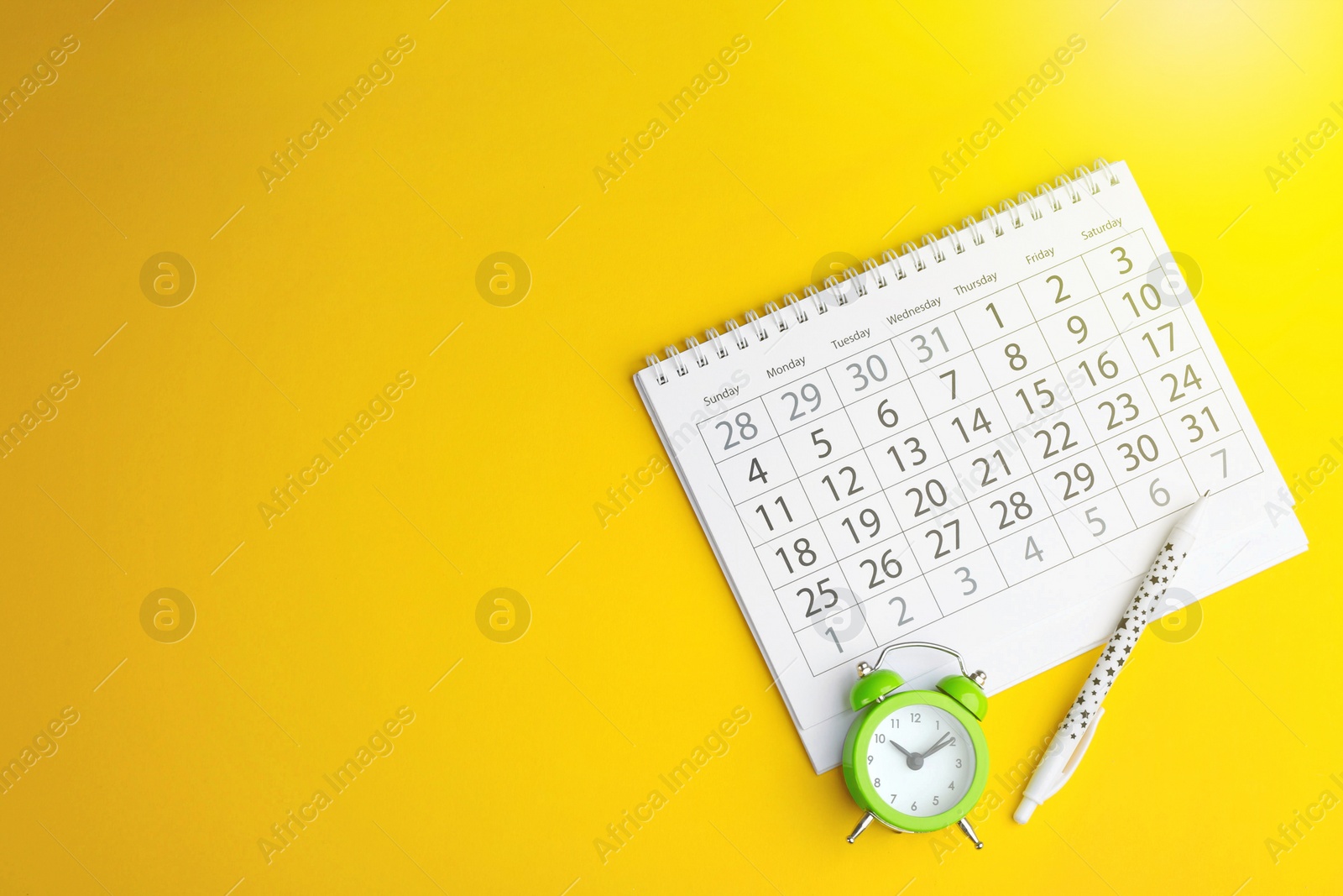 Image of Calendar, pen and alarm clock on yellow background, flat lay. Space for text