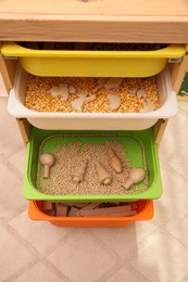 Photo of Shelving unit with different sensory games indoors, above view. Montessori toy