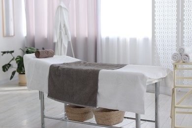 Comfortable massage table with clean towels in spa center