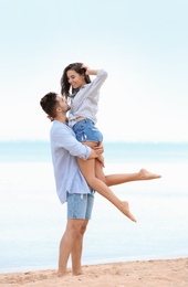 Happy young couple spending time together on beach near sea