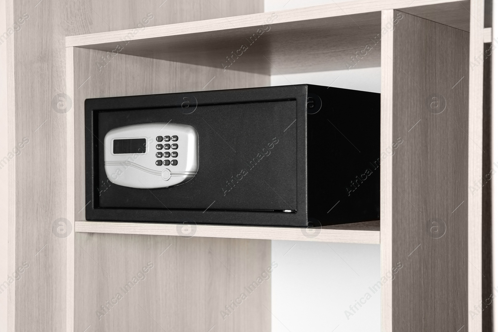 Photo of Black steel safe with electronic lock in wooden closet