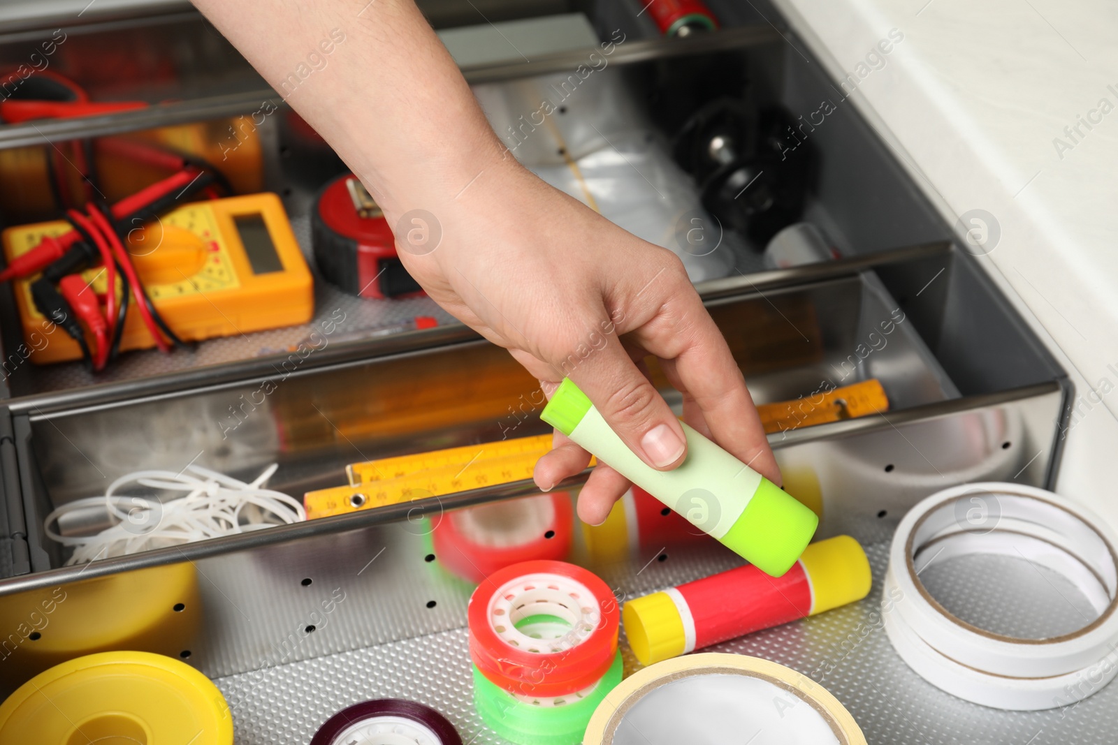 Photo of Man taking glue from drawer indoors, closeup