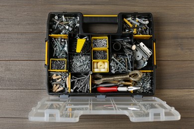 Photo of Box with different furniture fittings and tools on wooden table, top view