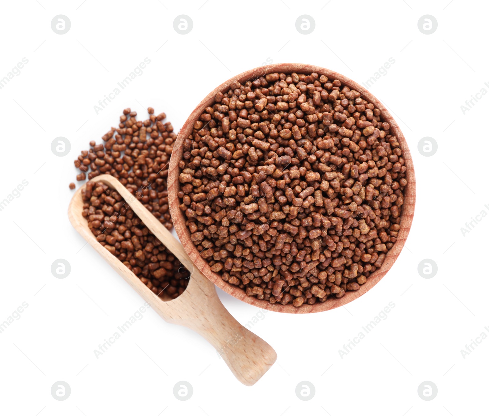 Photo of Wooden bowl and scoop with buckwheat tea granules on white background