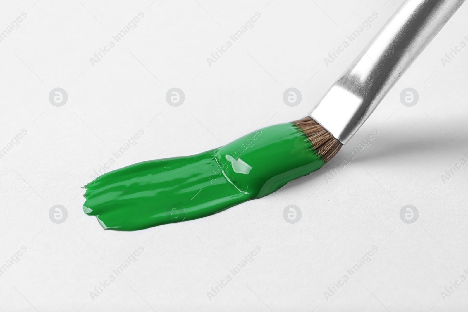 Photo of Brush with color paint and stroke on white background
