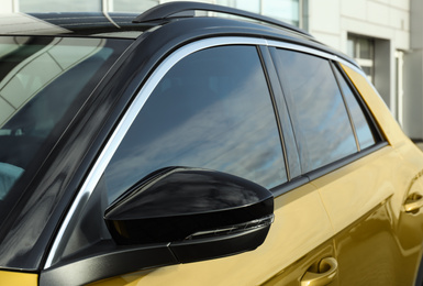 Modern car with tinting foil on window outdoors, closeup
