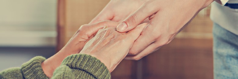 Caregiver helping elderly woman at home, closeup. Banner design