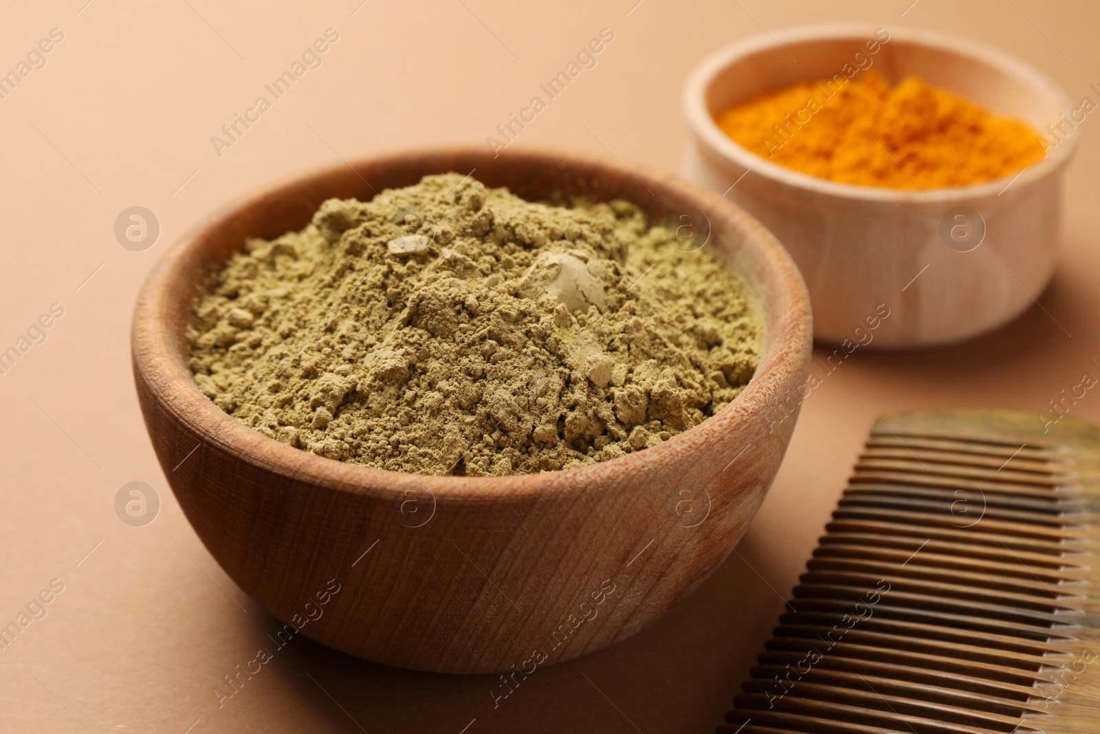 Photo of Comb, henna and turmeric powder on beige background, closeup. Natural hair coloring