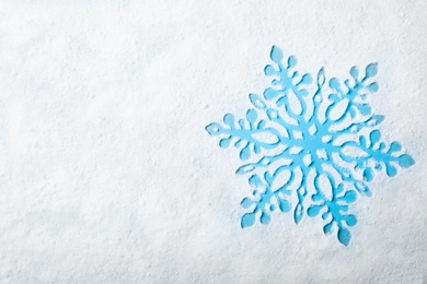 Beautiful flake silhouette in snow on color background, top view with space for text