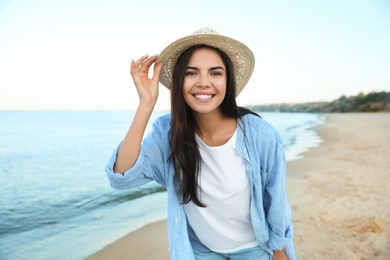 Photo of Beautiful young woman in casual outfit on beach