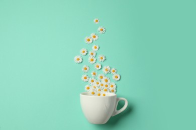 Photo of Flat lay composition with daisy flowers and ceramic cup on turquoise background