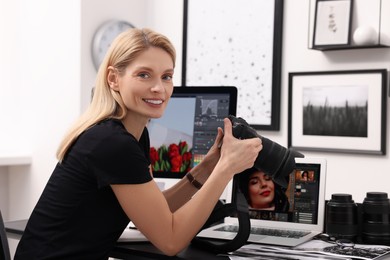 Photo of Professional photographer with digital camera at table in office