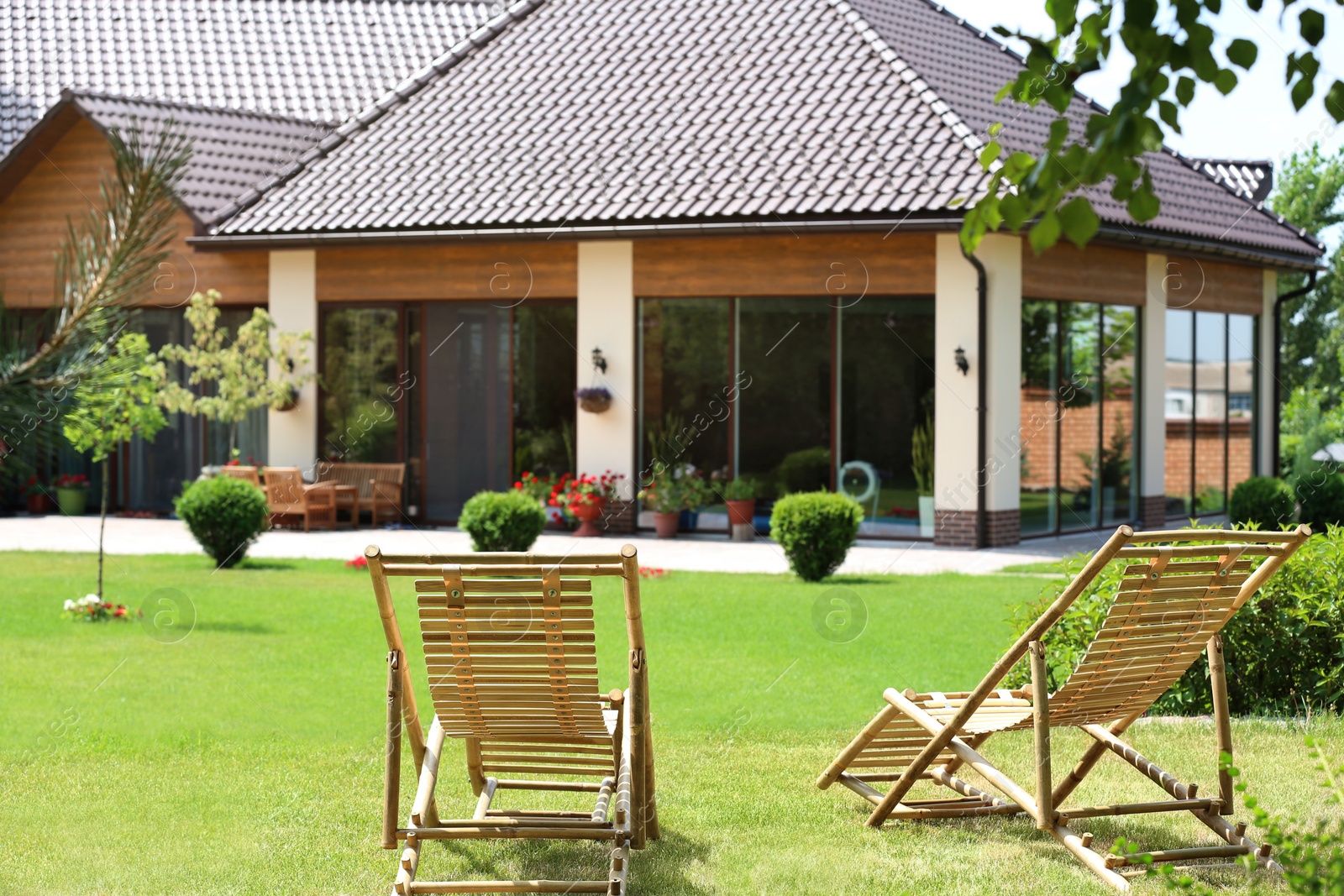 Photo of Wooden deck chairs in beautiful garden on sunny day