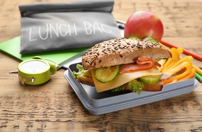 Photo of Lunch box with appetizing food and bag on table