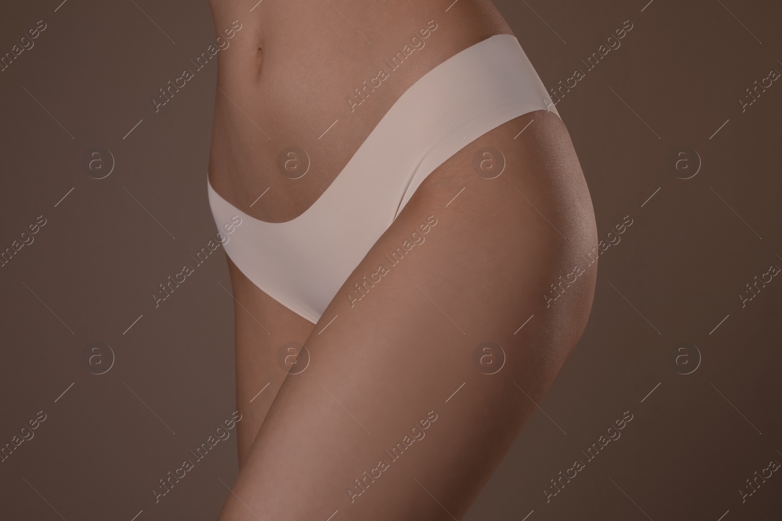 Photo of Slim woman with smooth skin in underwear on beige background, closeup. Cellulite problem concept
