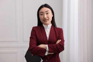 Portrait of happy notary with crossed arms in office