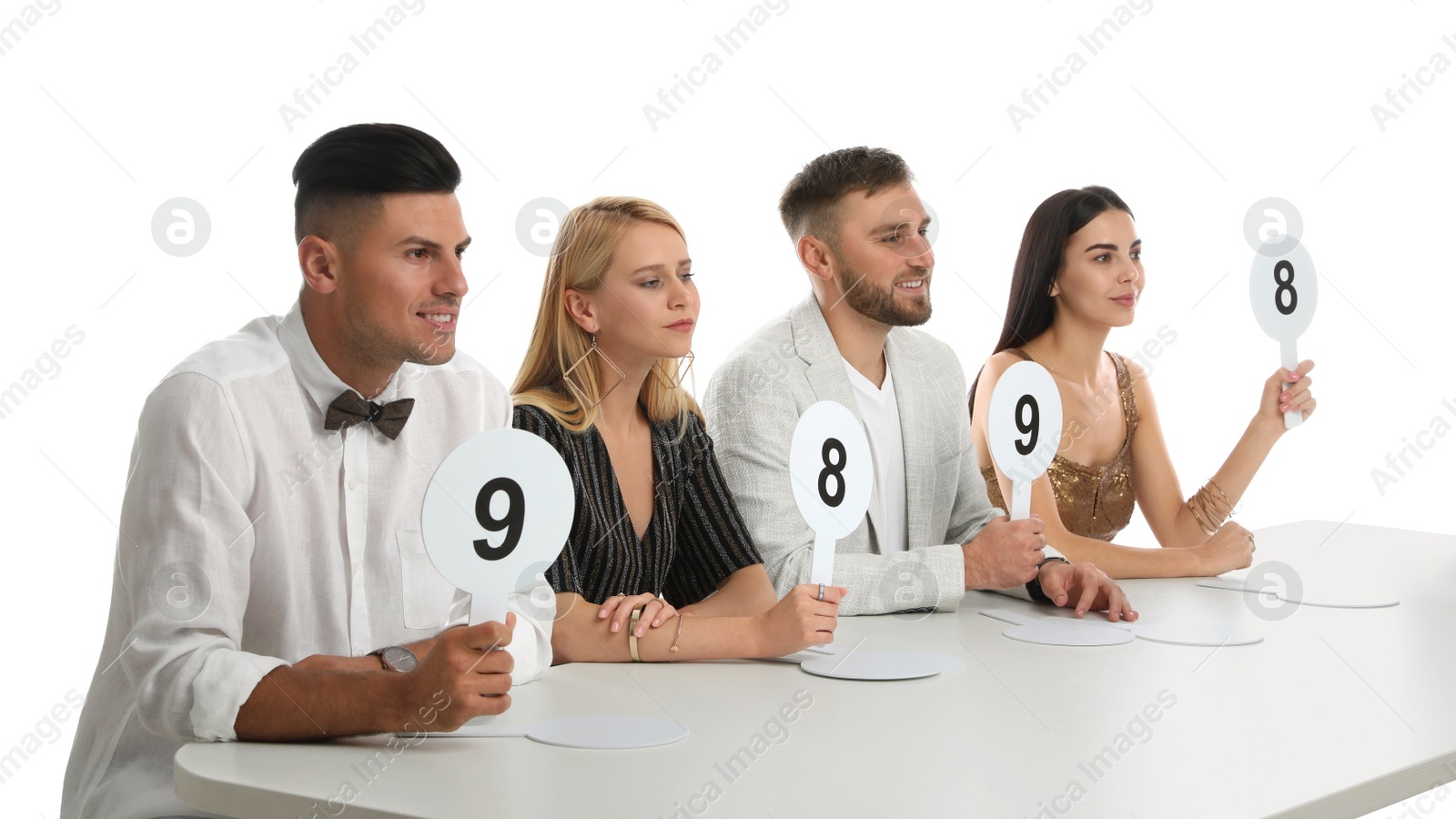 Photo of Panel of judges holding different score signs at table on white background