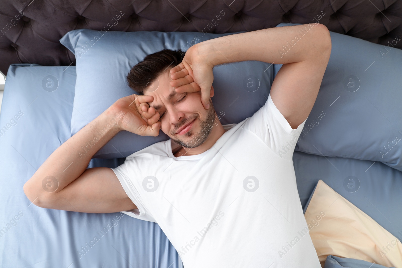 Photo of Sleepy man lying on pillow, view from above. Bedtime