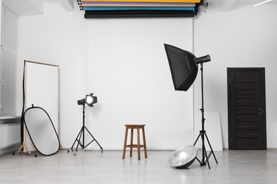 White photo background, stool and professional lighting equipment in studio