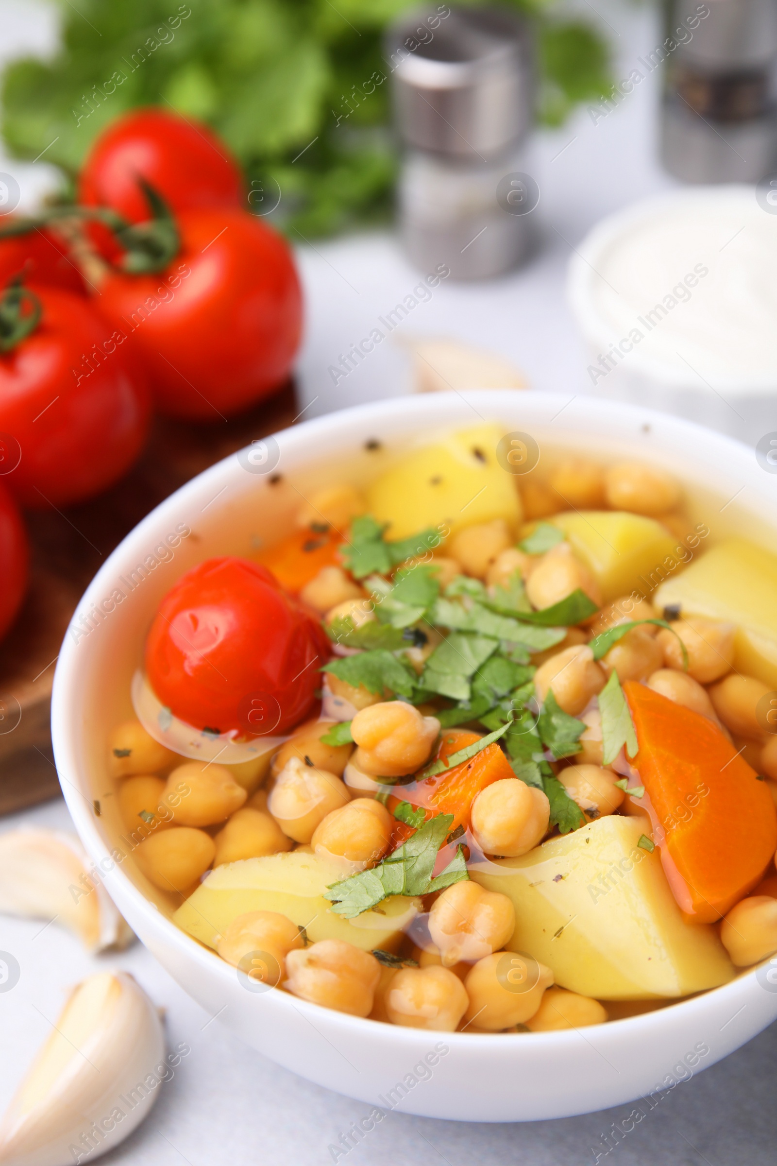 Photo of Tasty chickpea soup in bowl served on light grey table