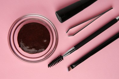 Photo of Flat lay composition with eyebrow henna and professional tools on pink background