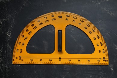 Photo of Protractor with measuring length and degree markings on blackboard, top view