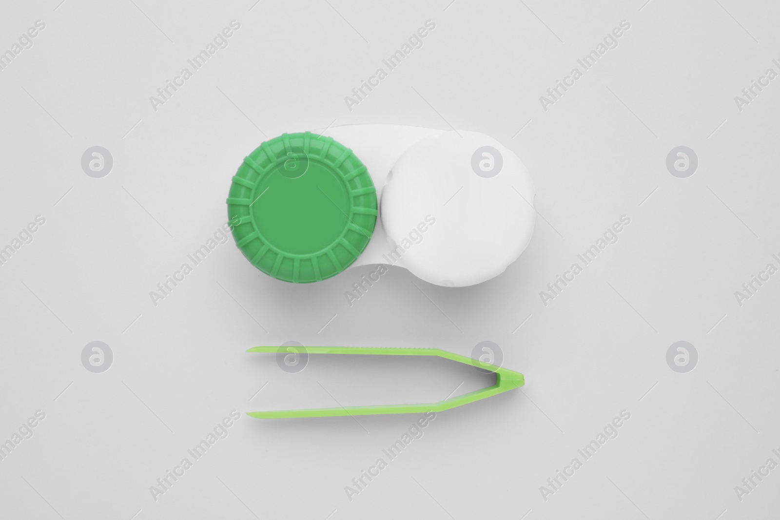 Photo of Case with contact lenses and tweezers on white background, flat lay