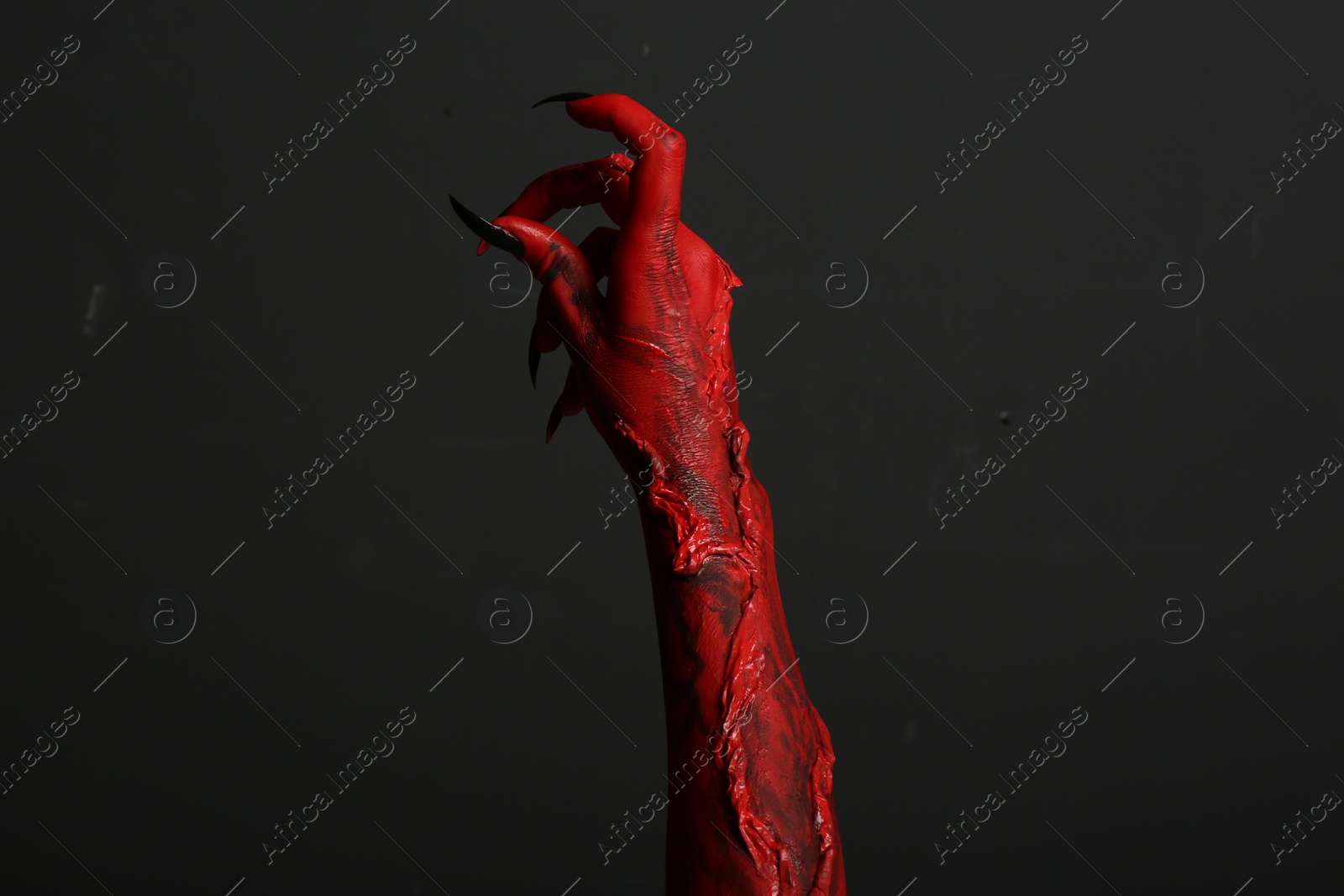 Photo of Scary monster on black background, closeup of hand. Halloween character