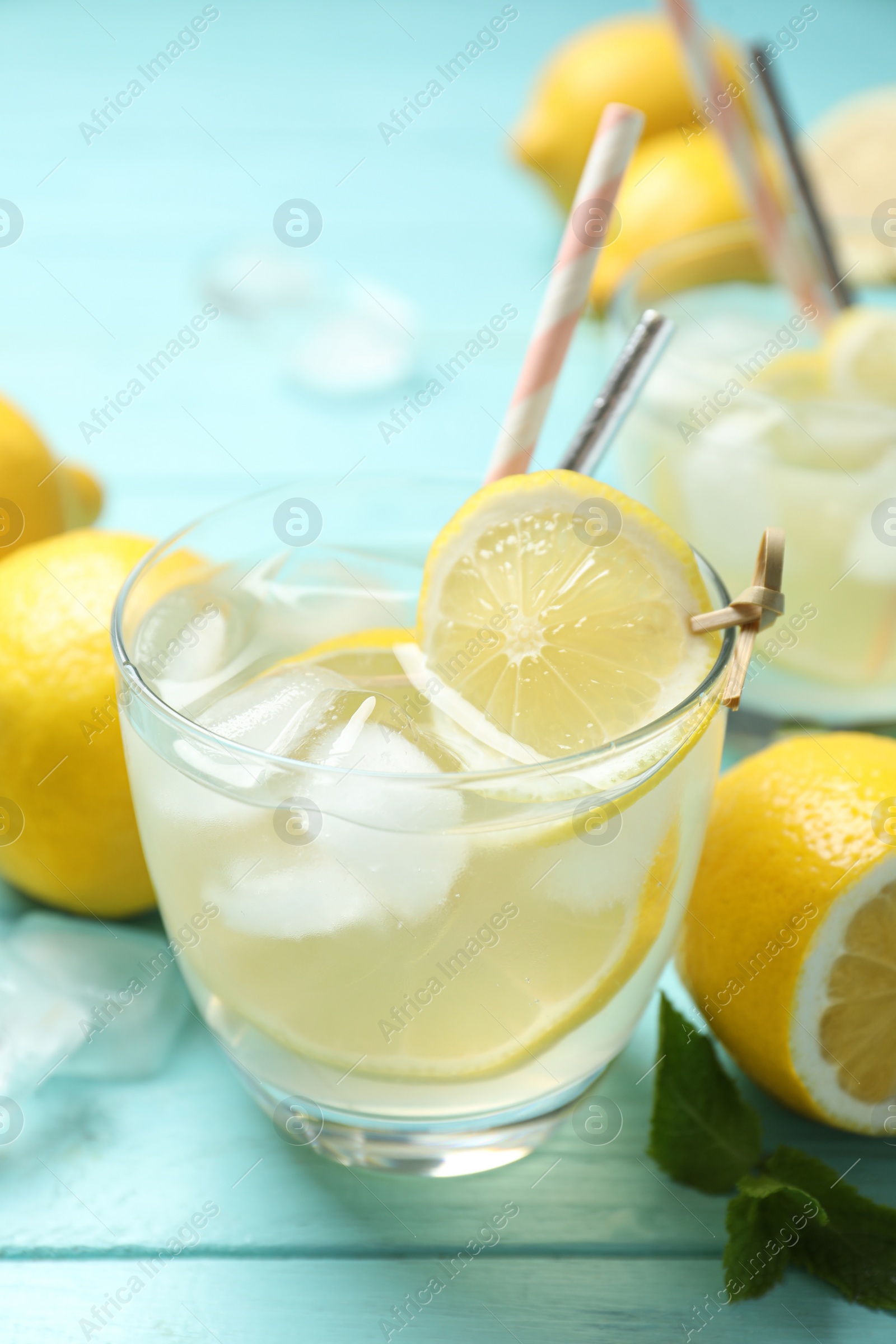 Photo of Natural lemonade on light blue wooden table, closeup. Summer refreshing drink