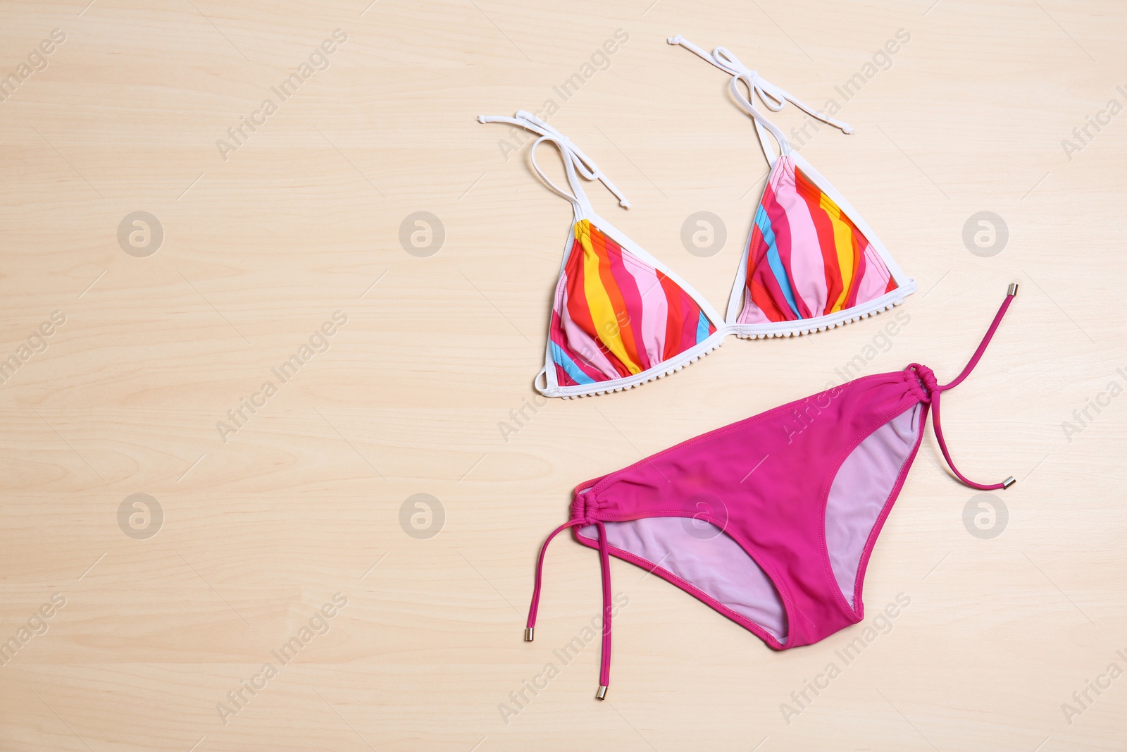 Photo of Beautiful bikini on wooden background, top view