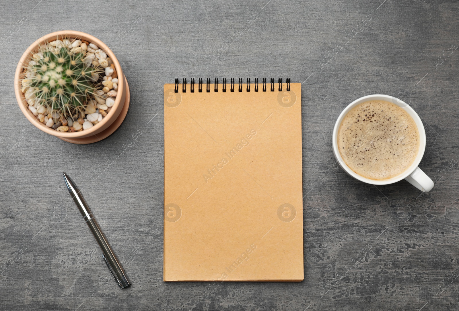 Photo of Flat lay composition with notebook and cup of coffee on grey background