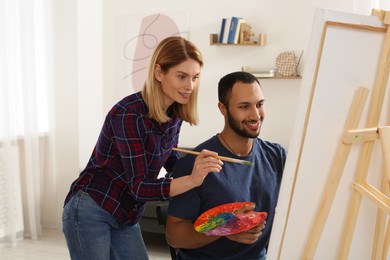 Photo of Artist teaching her student to paint in studio. Creative hobby