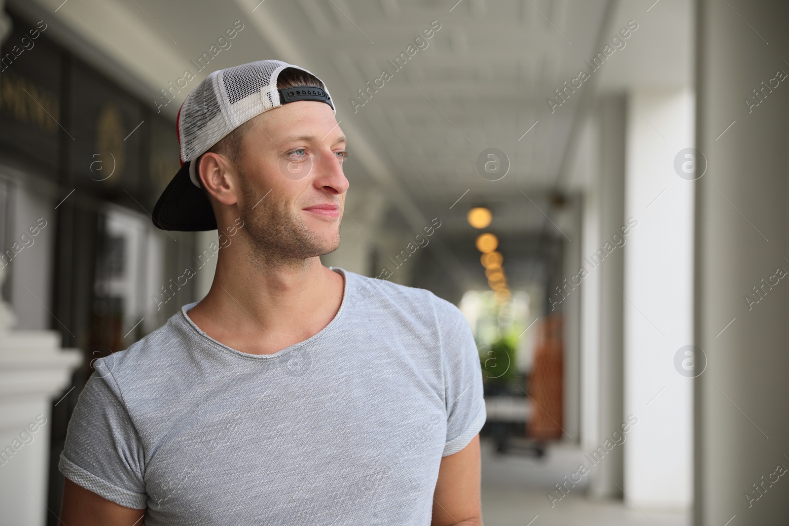 Photo of Handsome young man in stylish cap indoors, space for text