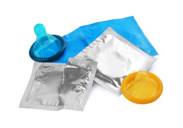 Photo of Packages and unpacked condoms isolated on white. Safe sex