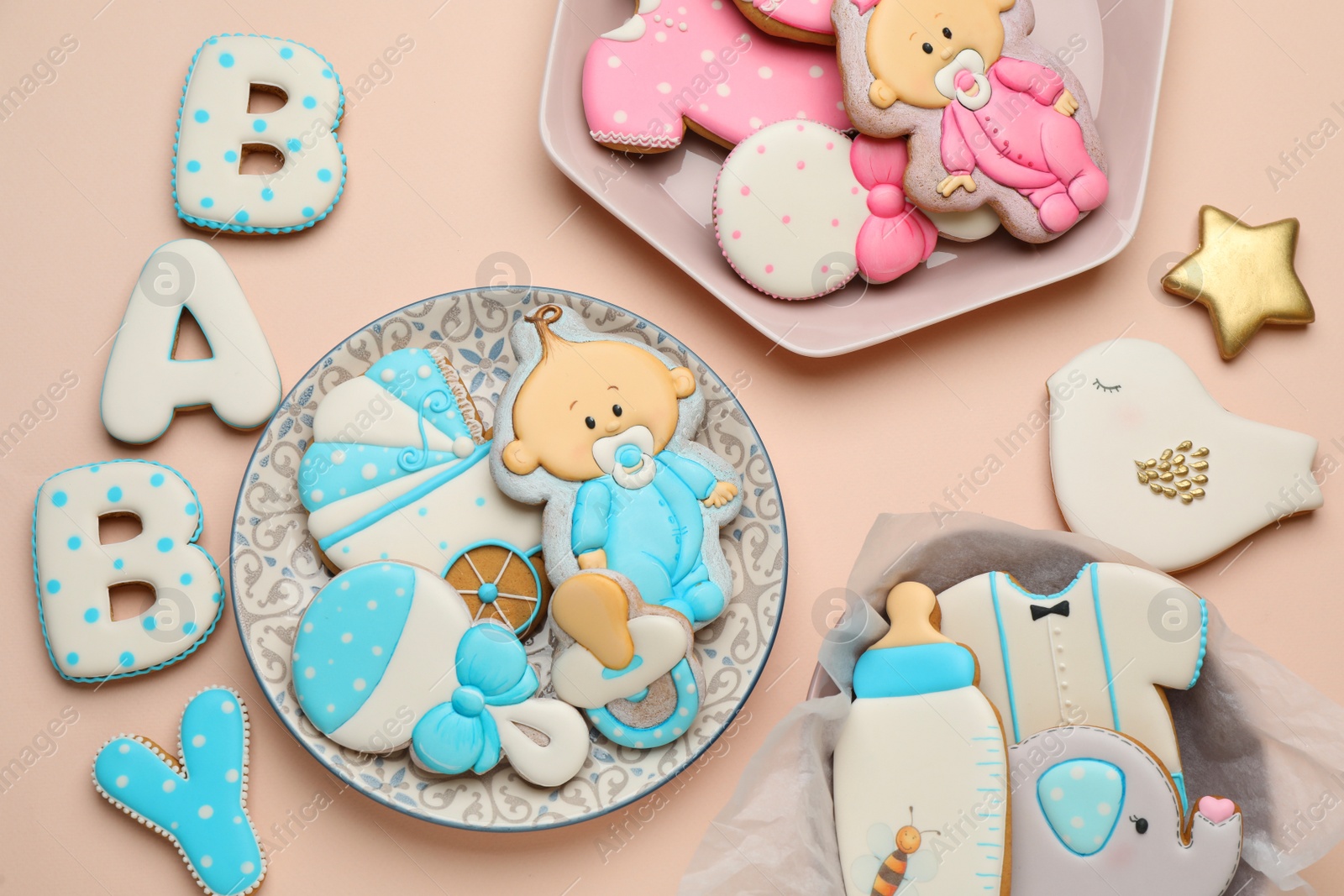 Photo of Set of baby shower cookies on light pink background, flat lay