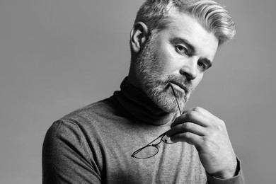 Portrait of handsome man on grey background. Black and white effect