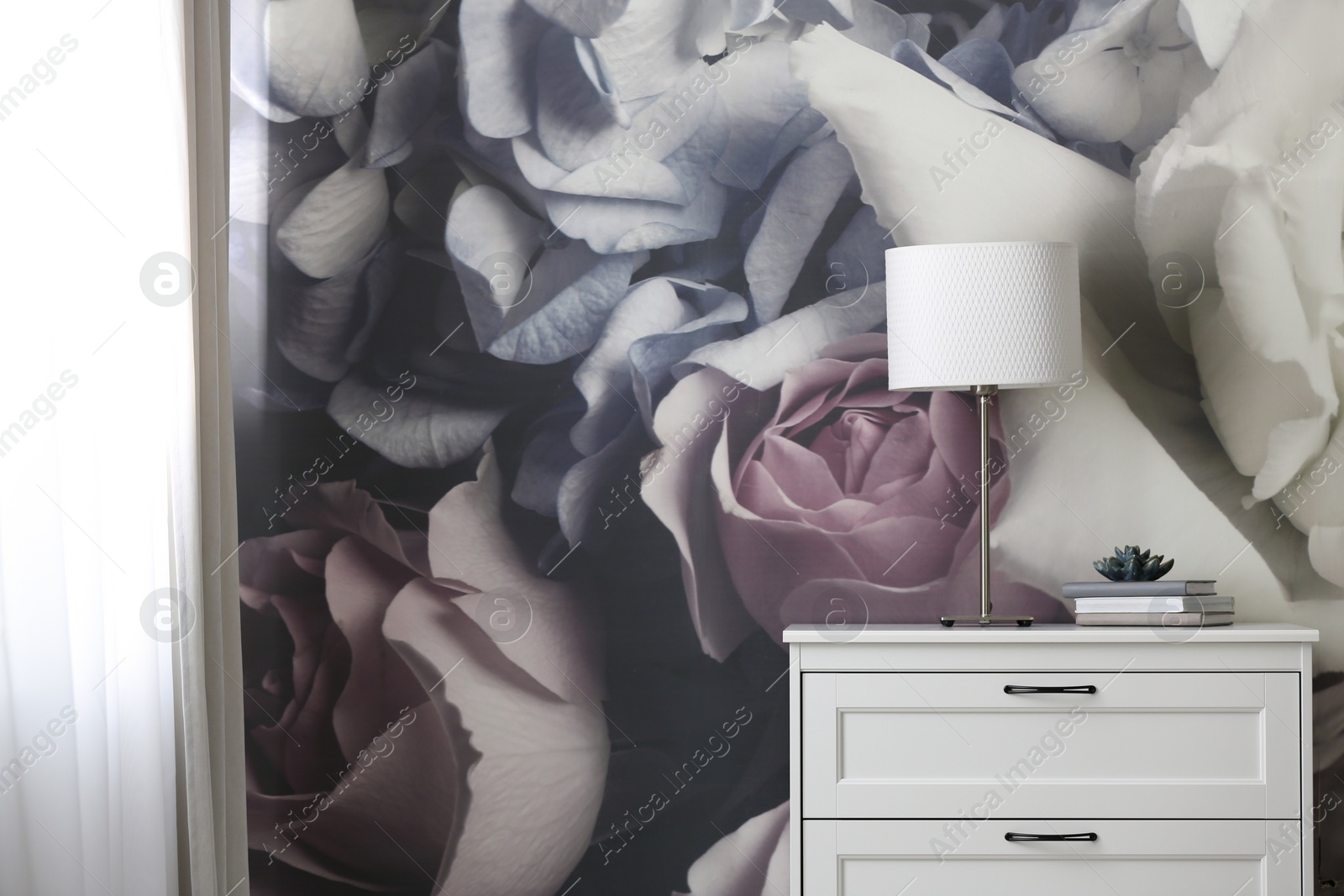 Photo of Stylish chest of drawers near painted wall in living room