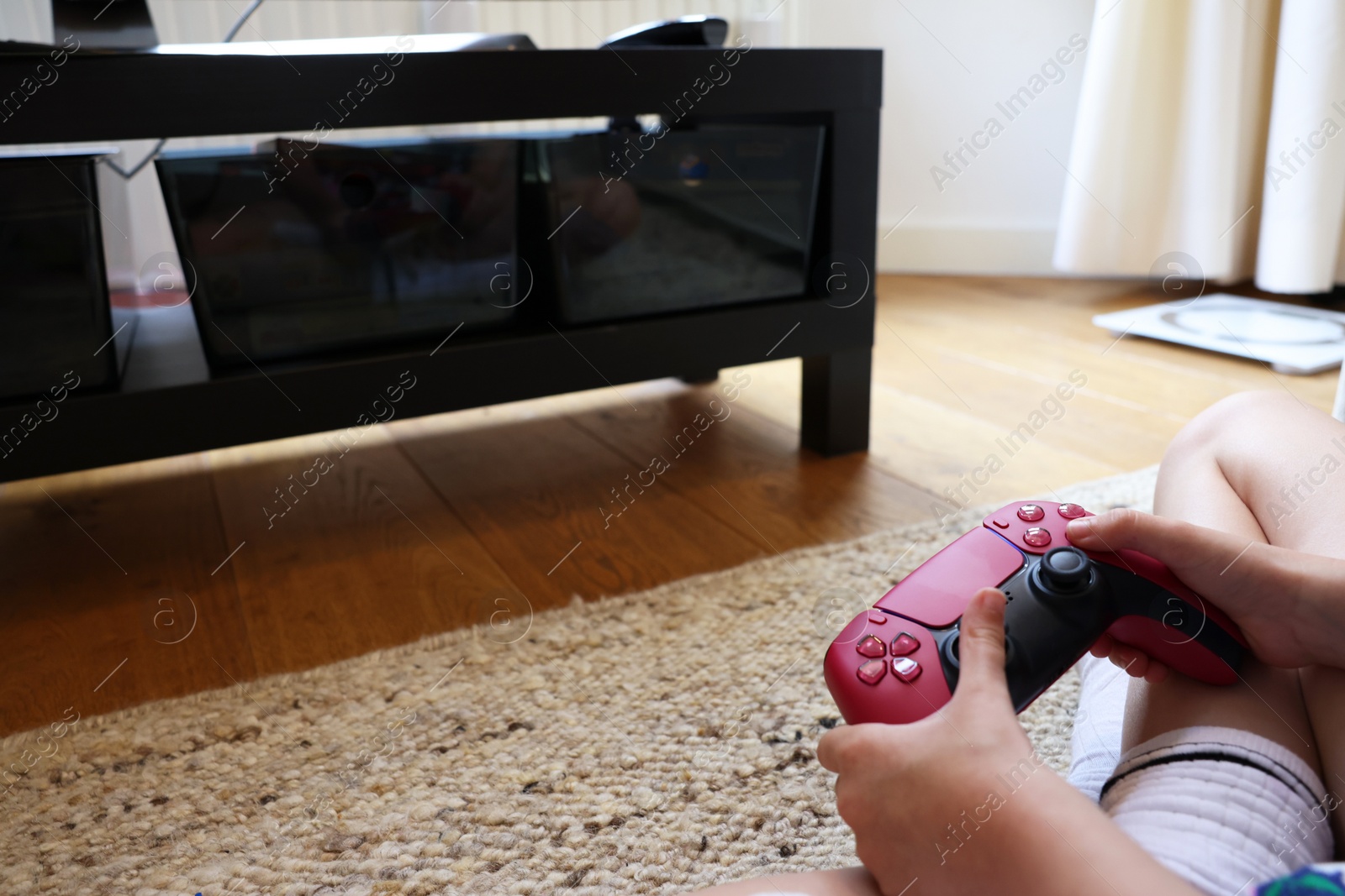 Photo of Child playing video games with controller at home, closeup. Space for text