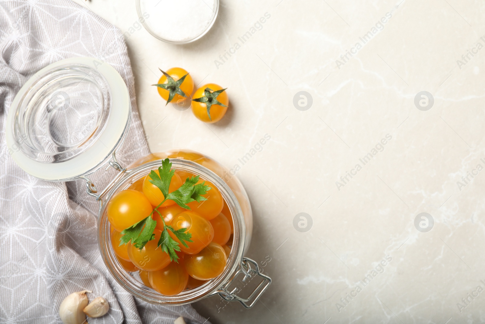 Photo of Pickling jar with fresh yellow tomatoes on light table, flat lay. Space for text