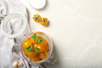 Pickling jar with fresh yellow tomatoes on light table, flat lay. Space for text