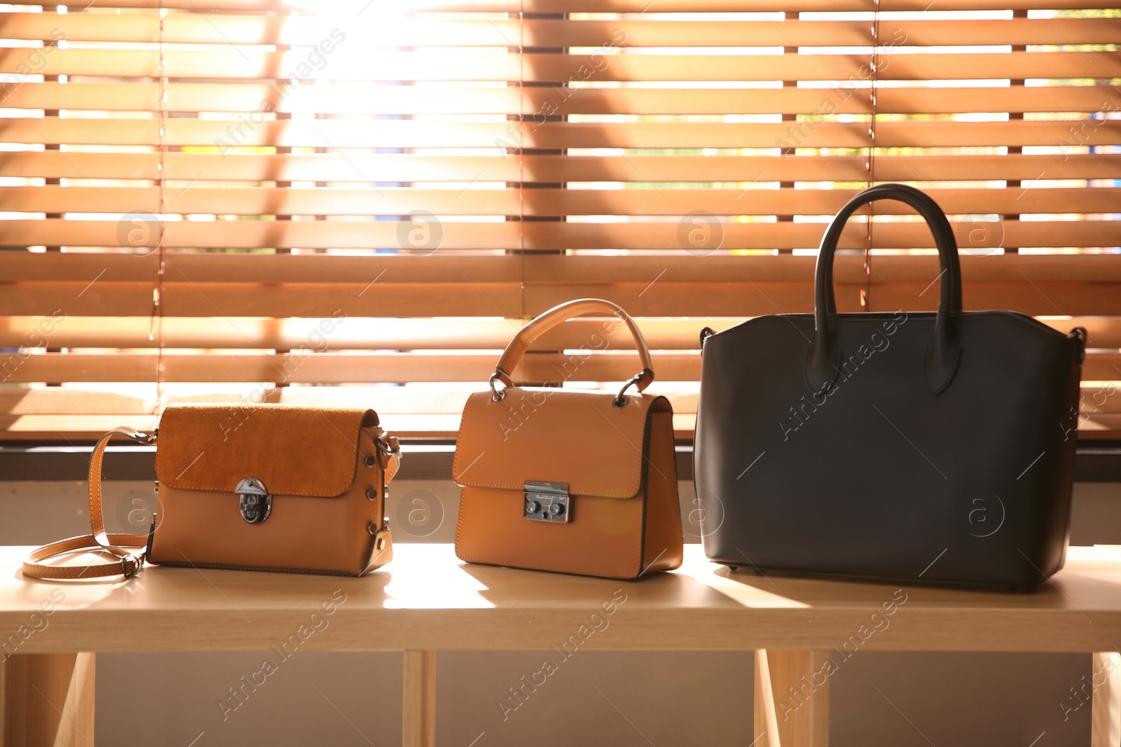 Photo of Stylish woman's bags on shelf in boutique